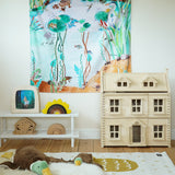 Wonderie Play Cloth - Down By The Pond on a play room wall, with toys and a dolls house underneath