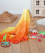 Wonderie organic cotton orange amber play cloth in volcano dinosaur small world set up using a Grimm's rainbow and Holzitger dinosaurs.