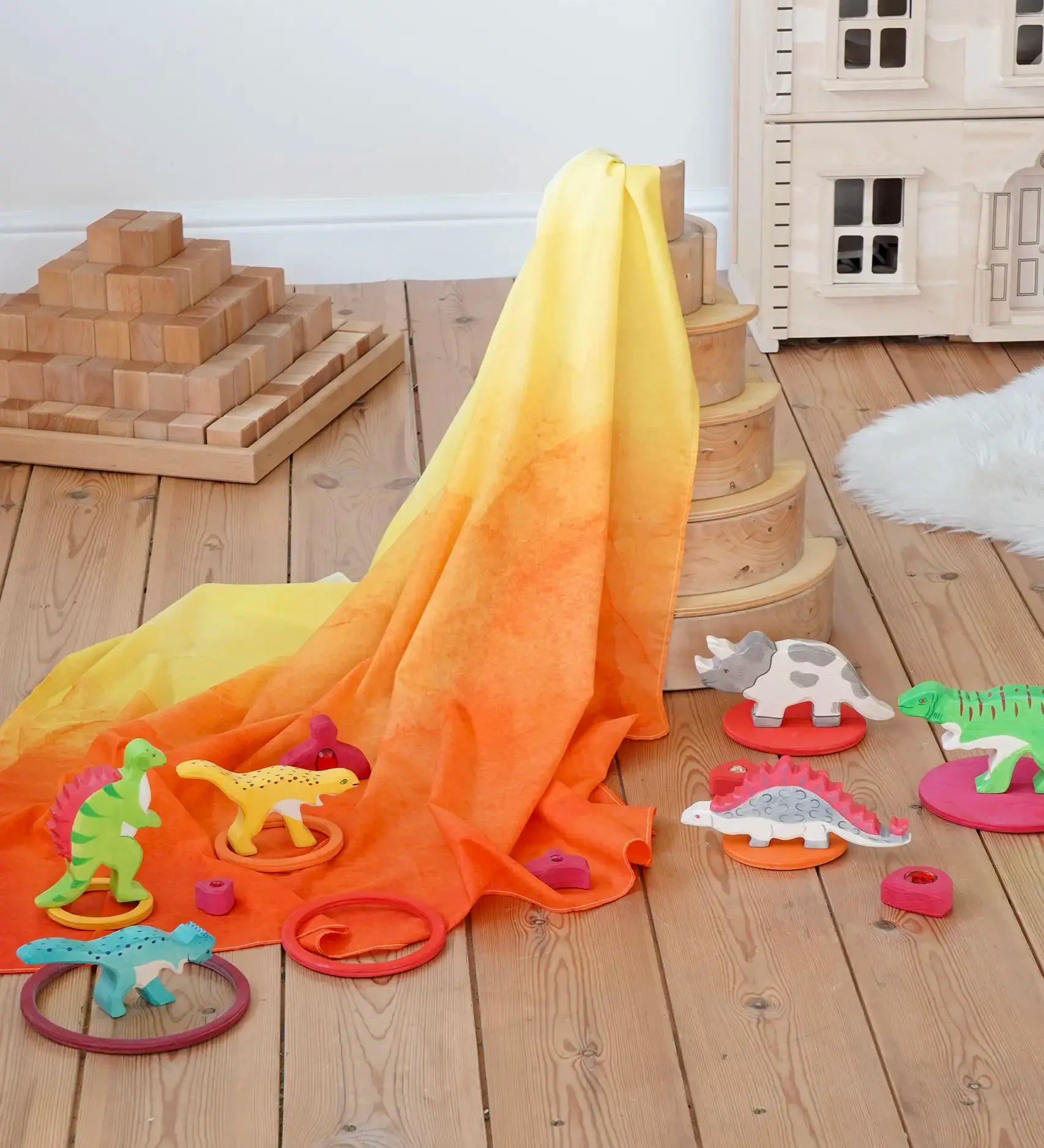 Wonderie organic cotton orange amber play cloth in volcano dinosaur small world set up using a Grimm's rainbow and Holzitger dinosaurs.