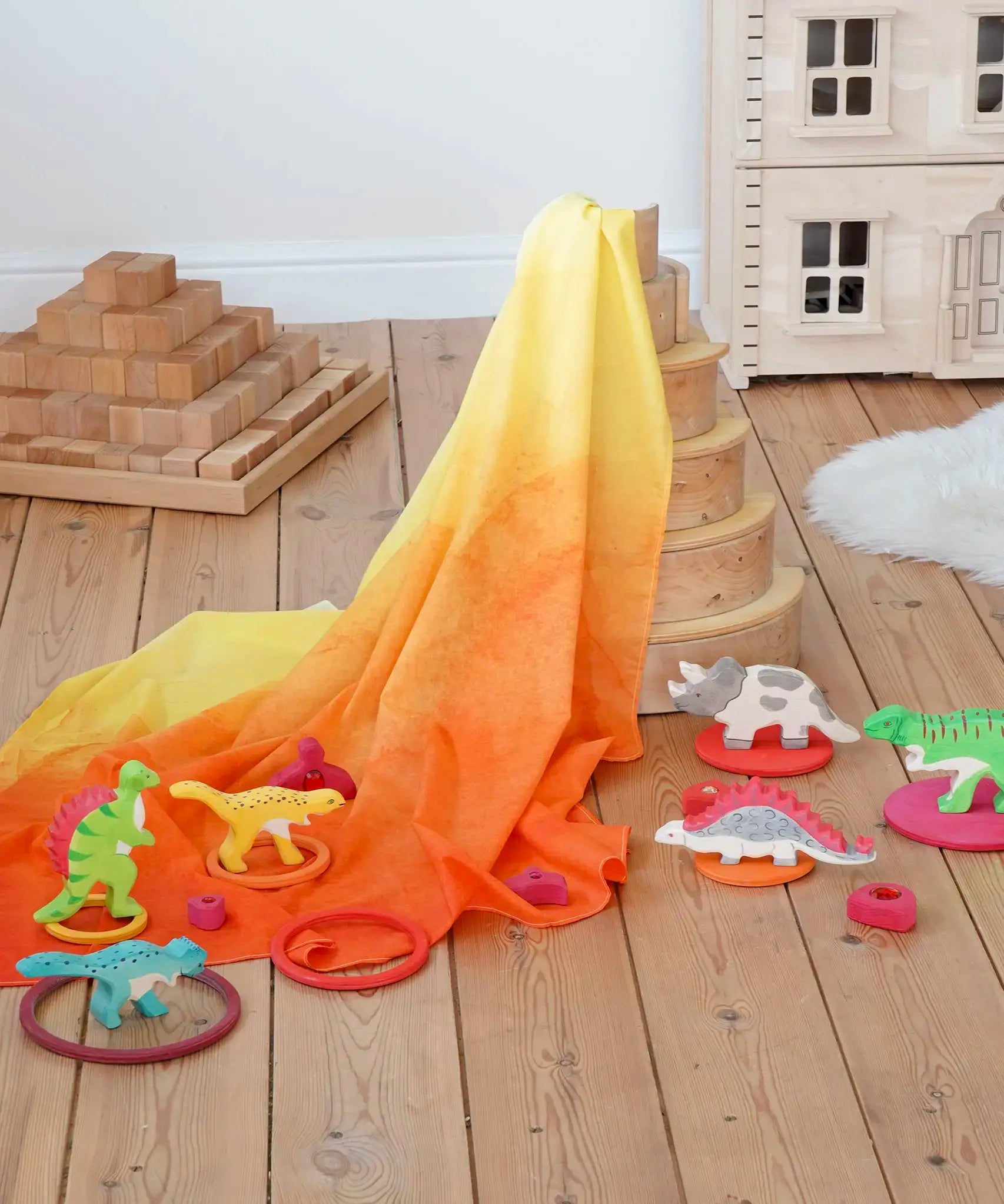 Wonderie organic cotton orange amber play cloth in volcano dinosaur small world set up using a Grimm's rainbow and Holzitger dinosaurs.