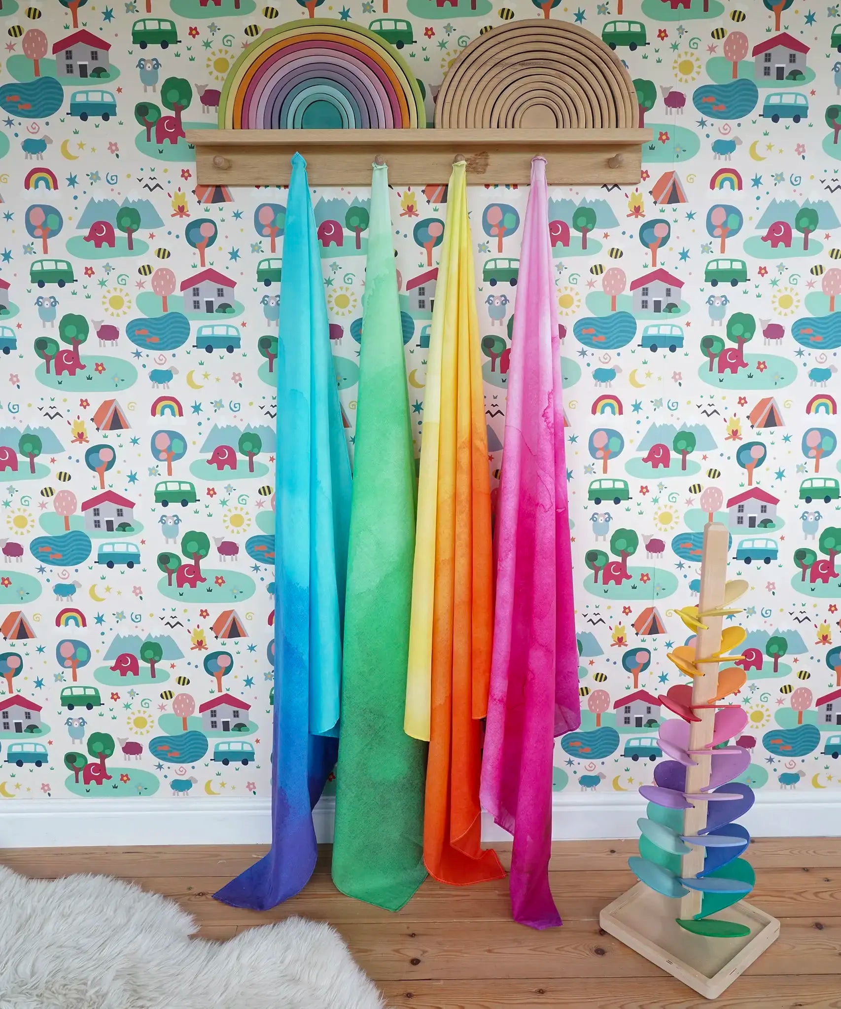 Wonderie organic cotton play cloths in green, blue, yellow and pink in the Babipur playroom next to a Magic Wood marble tree and Grimm's rainbows.