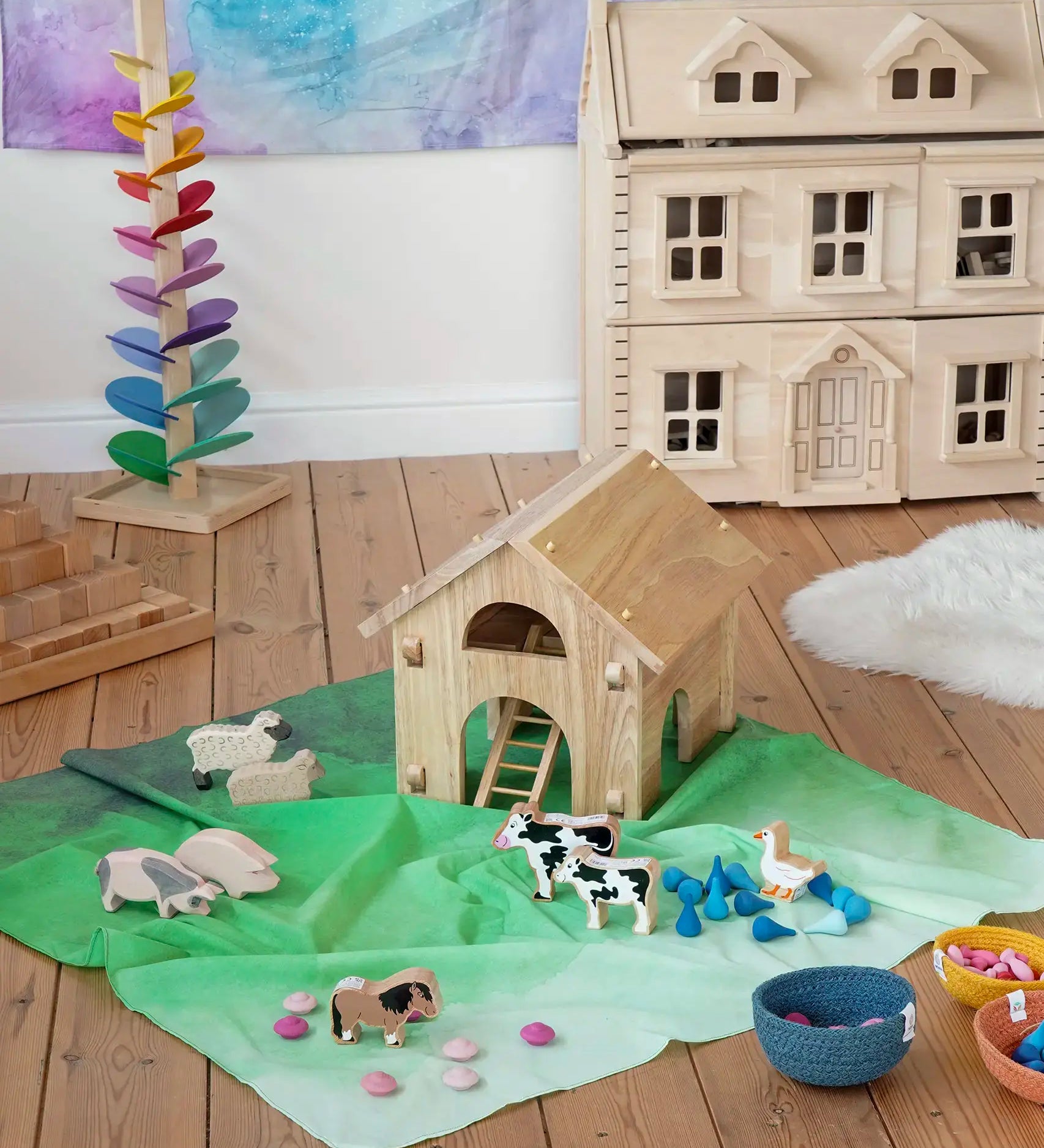 Wonderie organic cotton large sheer play cloth in juniper green used as grass in a farm small world play set up with Bbaipur animals and Lanka Kade barn.