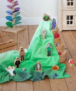 Wonderie organic cotton play cloth in green used for a Halloween play scene featuring Lanka Kade figures and a Grimm's rainbow.