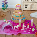 Wonderie organic cotton play cloth in pink used for a princess castle small world play scene featuring a Grimm's rainbow and Ostheimer fairytale figures.