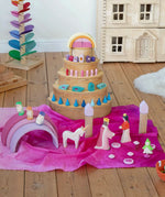 Wonderie organic cotton play cloth in pink used for a princess castle small world play scene featuring a Grimm's rainbow and Ostheimer fairytale figures.