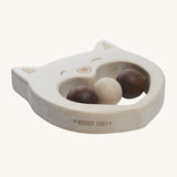 The side of the Wooden Story Smiley Cat Rattle, showing the natural wood grain of the rattle and the words "Wooden Story" etched into the side.