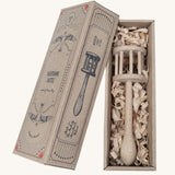 The Wooden Story Nighthawk Rattle comes in a vintage inspired, decorated cardboard box and is laid on wood shavings inside the box.