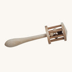 Wooden Story Nighthawk Rattle is a beautiful, wooden musical and sensory rattle which children can roll along the floor, shake or rub between their palms. The rattle head is like a little wooden cage with wooden balls inside, on top of a wooden stick that gets wider towards the end. The image is on a cream background