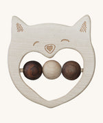 The Wooden Story Smiley Cat Rattle, is a beautiful wooden, sensory toy, perfect for teething. The rattle has a cat face on the front, and three wooden beads in the middle. 2 in dark wood and 1 in light wood. The image is on a cream background