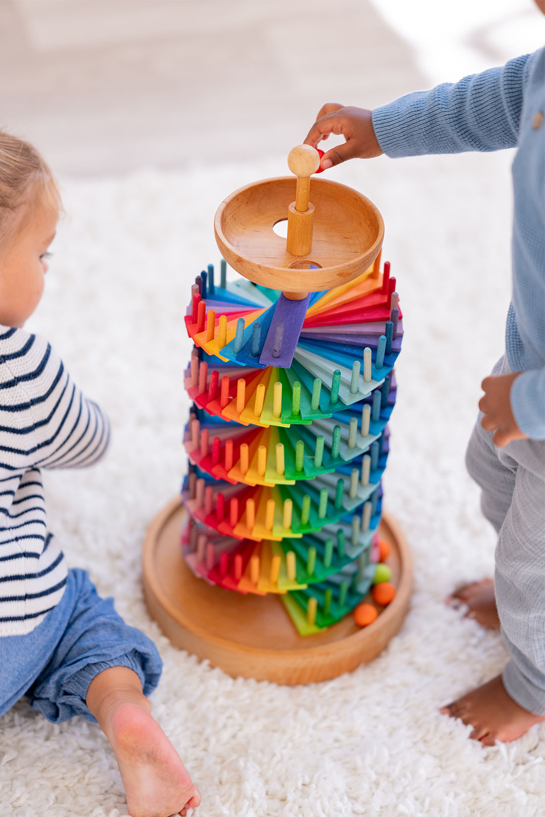 Children playing with the Grimm's wooden marble run in playroom to represent Babipur TOys