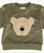 A close up of the Wooly Organic embroidered sweater in tea leaf green /savannah available at Babipur showing the cute fluffy teddy bear embroidery on the front and popper fastener detail