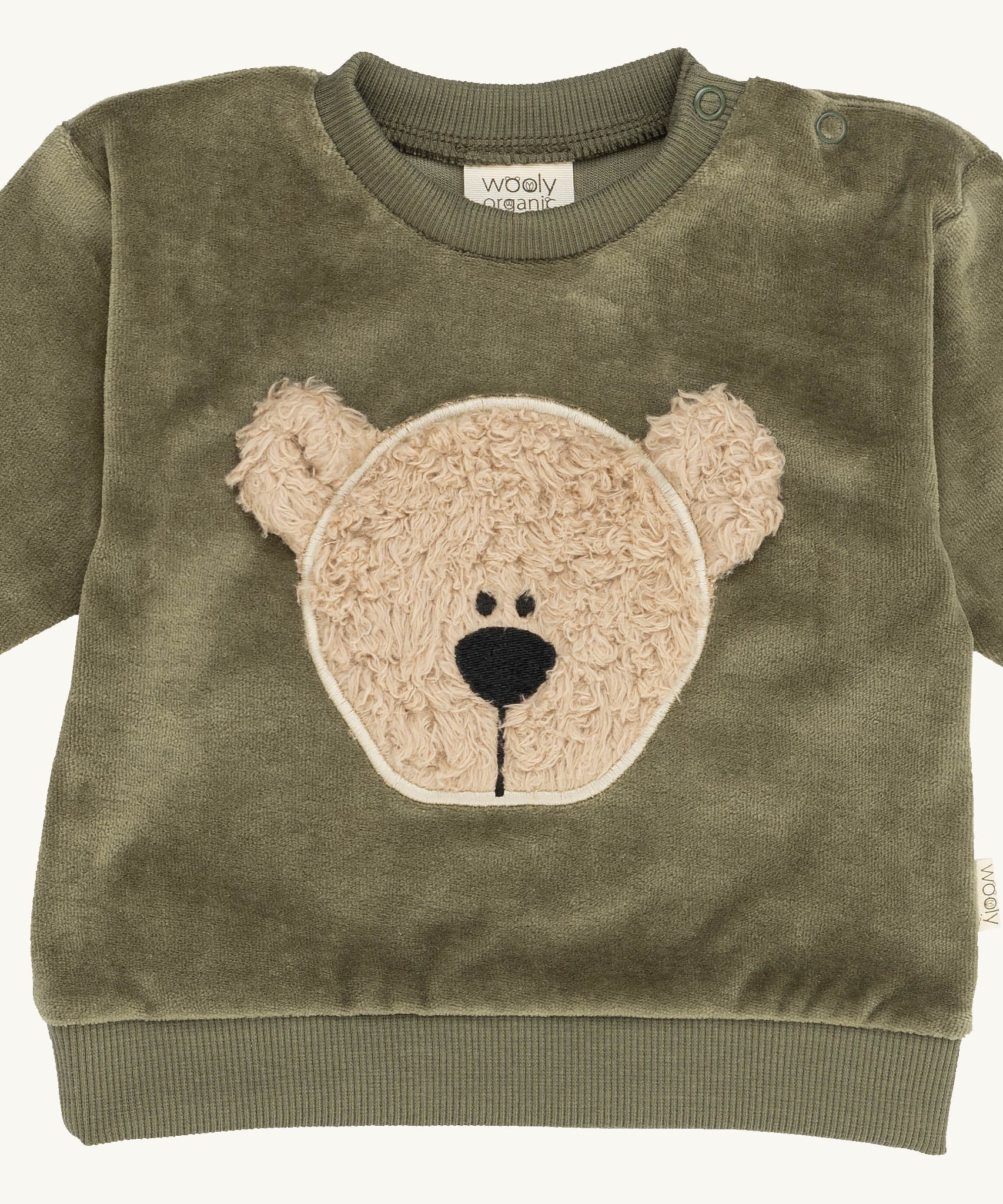 A close up of the Wooly Organic embroidered sweater in tea leaf green /savannah available at Babipur showing the cute fluffy teddy bear embroidery on the front and popper fastener detail