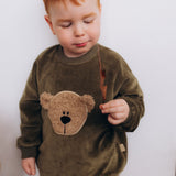 A child modelling the the Wooly Organic embroidered GOTS organic cotton velour sweater in tea leaf /savannah available at Babipur showing the fluffy teddy embroidery on the front