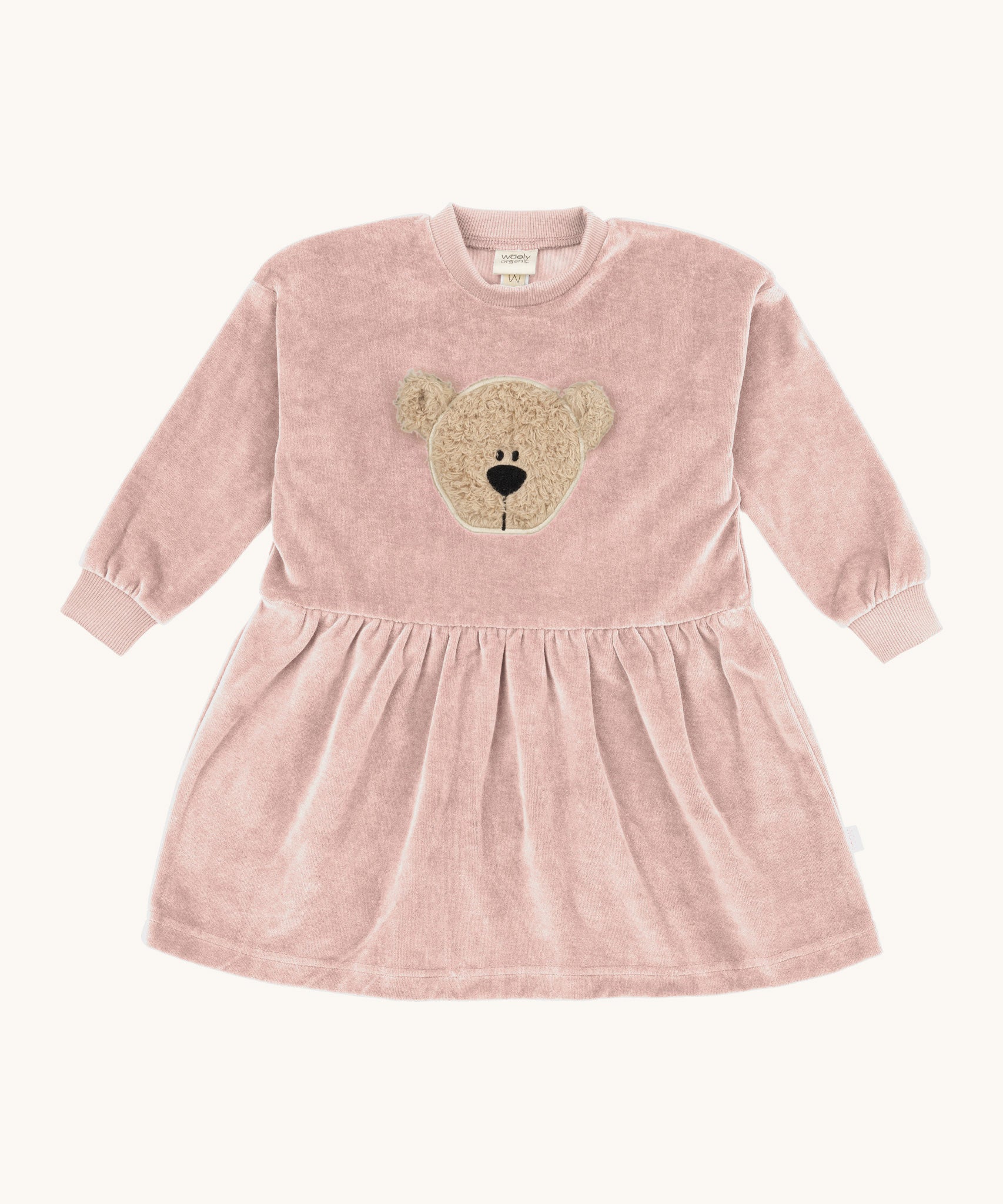Wooly Organic embroidered velour dress in pale blush pink /savannah available at Babipur. A soft GOTS organic cotton velour sweater in light pink with a cute fluffy cream teddy bear on the front and elasticated arm cuffs 