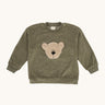 Wooly Organic embroidered velour sweater in tea leaf /savannah available at Babipur. A soft GOTS organic cotton velour sweater in light green with a cute fluffy cream teddy bear on the front.