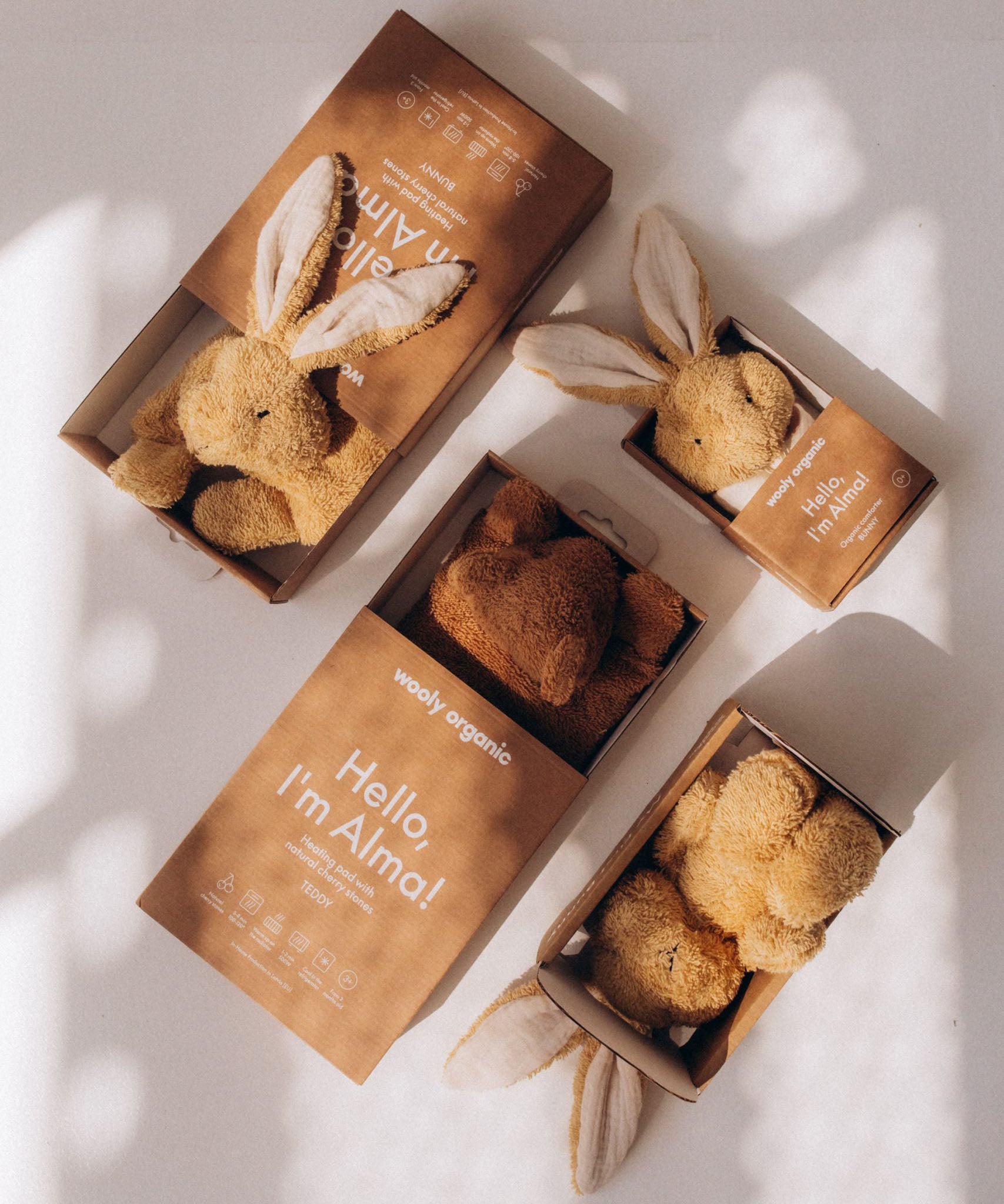 A collection of Wooly Organic soft cotton toys including the small light brown bunny rabbit toy, available at Babipur