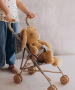 A toddler pushing the Wooly Organic soft cotton bunny rabbit toy in a toy pram. Bunny rabbit available at Babipur. 