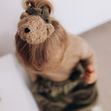 A child wearing the Wooly Organic velour scrunchy in tea leaf green available at Babipur. 