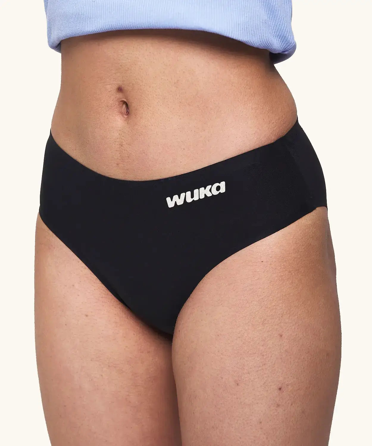 Side of model wearing the WUKA teen stretch brief heavy flow Period Pants showing the white branding 