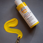 A Close up view of the Natural Earth Paint brilliant yellow acrylic paint with a brush 