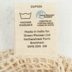 A close up view of the A Slice Of Green small mesh recycled cotton produce bag showing the certifications tag 