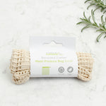 A Slice Of Green small mesh recycled cotton produce bag laid flat on a stone surface. 