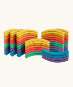 Set of 72 Abel curved wooden blocks in rainbow colors, including yellow, orange, red, purple, blue and green placed in stacks. 12 blocks in each colour. 