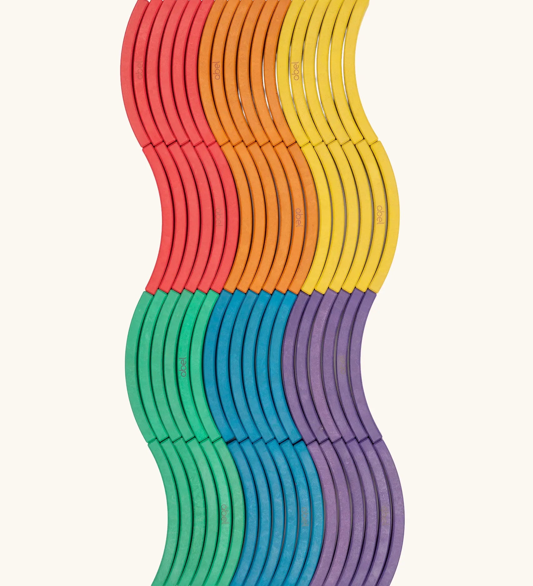 Set of 72 Abel curved wooden blocks in rainbow colors, including yellow, orange, red, purple, blue and green placed in a wavy pattern. 12 blocks in each colour. 