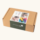 Set of 72 Abel curved wooden blocks in rainbow colors, including yellow, orange, red, purple, blue and green in their cardboard packaging box.