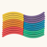 Set of 24 Abel curved wooden blocks in rainbow colors, including yellow, orange, red, purple, blue and green arranged in a wavy pattern. Four blocks in each colour.