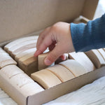 Close up of childs hand picking an Abel Golden Ratio toy block out from the box