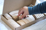 Close up of childs hand picking an Abel Golden Ratio toy block out from the box