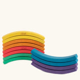 Set of 12 Abel curved wooden blocks in rainbow colors, including yellow, orange, red, purple, blue and green shown stacked.