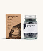 A jar of the Georganics activated charcoal toothpaste tablets with the box. 