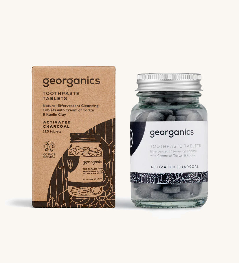 A jar of the Georganics activated charcoal toothpaste tablets with the box. 