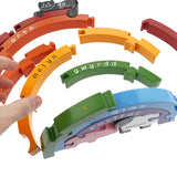 Close up of hand reaching out to pick up a piece of the Alphabet Jigsaw handmade wooden Welsh rainbow puzzle toy on a white background