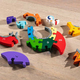 Alphabet Jigsaw eco-friendly multicoloured rainbow Rocket puzzle pieces laid out on a wooden background
