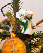 Ambrosius collectable Christmas rose fairy figure in a Christmas tree behind a slice of dried orange