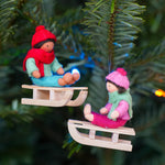 Close up of the Ambrosius handmade sledging boy and girl Christmas decorations hanging from a Christmas tree