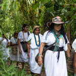 The female coffee farmers of ANEI walking through the farm in traditional indigenous clothing.