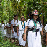 The female coffee farmers of ANEI walking through the farm in traditional indigenous clothing.