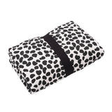 A baby lying down and looking at the colourful Leopard print on the Etta Loves Reversible Organic Cotton Baby Play Mat - Animal Print
