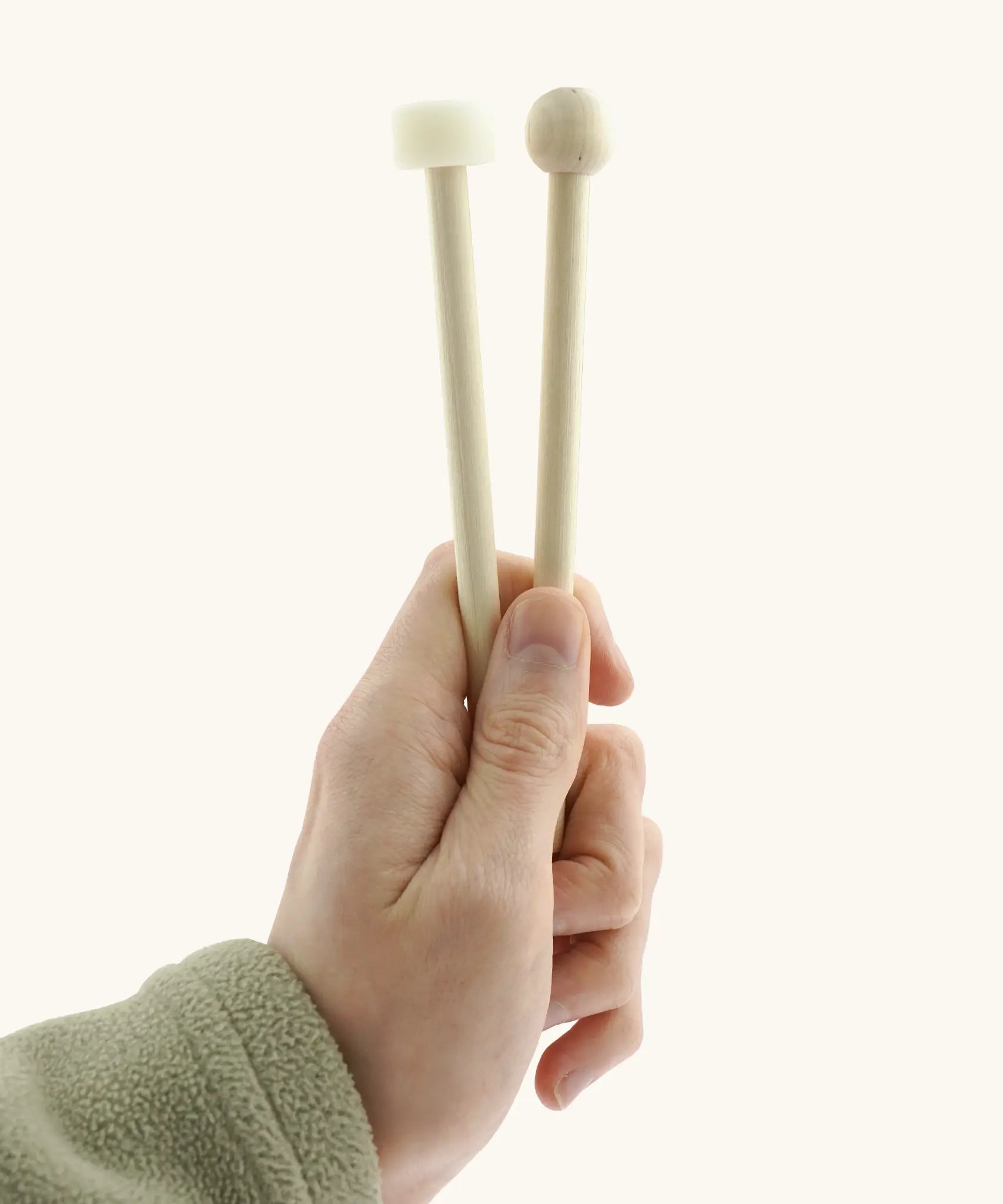 Wooden and rubber mallet for the Auris 3 tone glockenspiel held by a adult hand showing size 