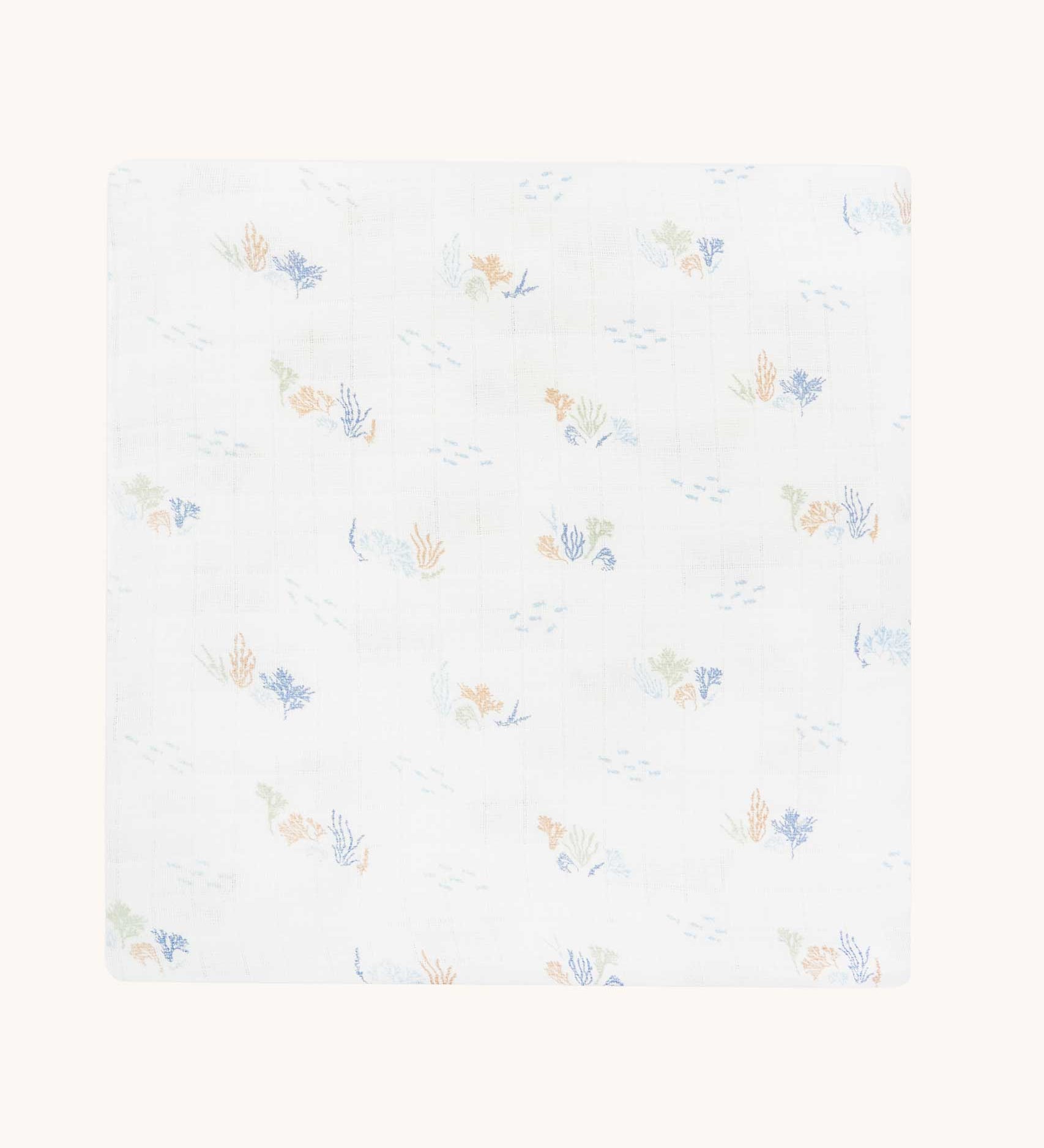 Avery Row Coastline baby Muslin Swaddle. The swaddle features a delicate coastline print that has corals and little blue fish. Avery Row have a collection of stylish nursery and baby essentials available at Babipur.