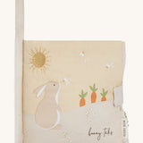 A soft beige Avery row baby book with a rabbit on the cover on a cream background.