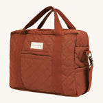 A orange and brown cinnamon coloured Avery Row baby changing bag on a cream background.