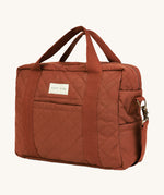 A orange and brown cinnamon coloured Avery Row baby changing bag on a cream background.
