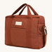 A orange and brown cinnamon coloured Avery Row baby changing bag on a cream background.