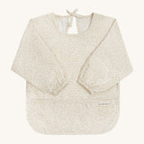 A light Avery row long sleeve bib with a daisy design on the front on a cream background.