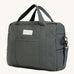 A dark charcoal colour Avery Row changing bag on a cream background.
